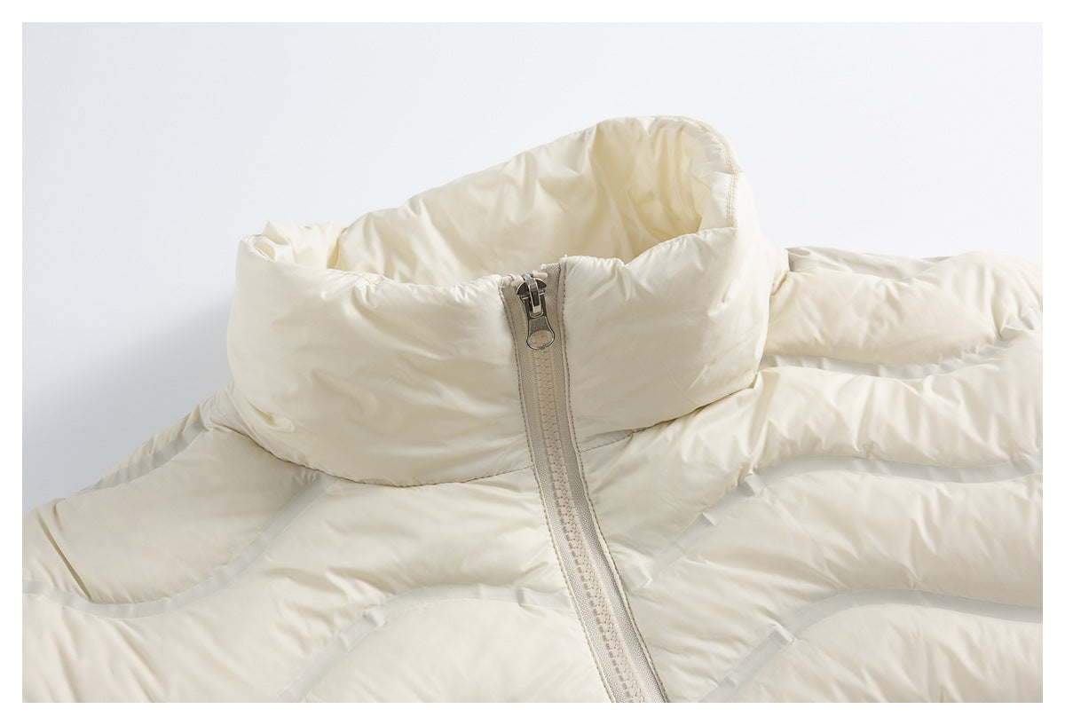 Close-up of an ivory padded jacket’s tall collar and front zipper.