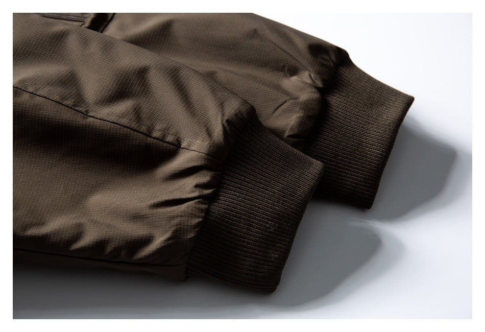 Close-up of a brown jacket's ribbed cuffs and sleeve seams.