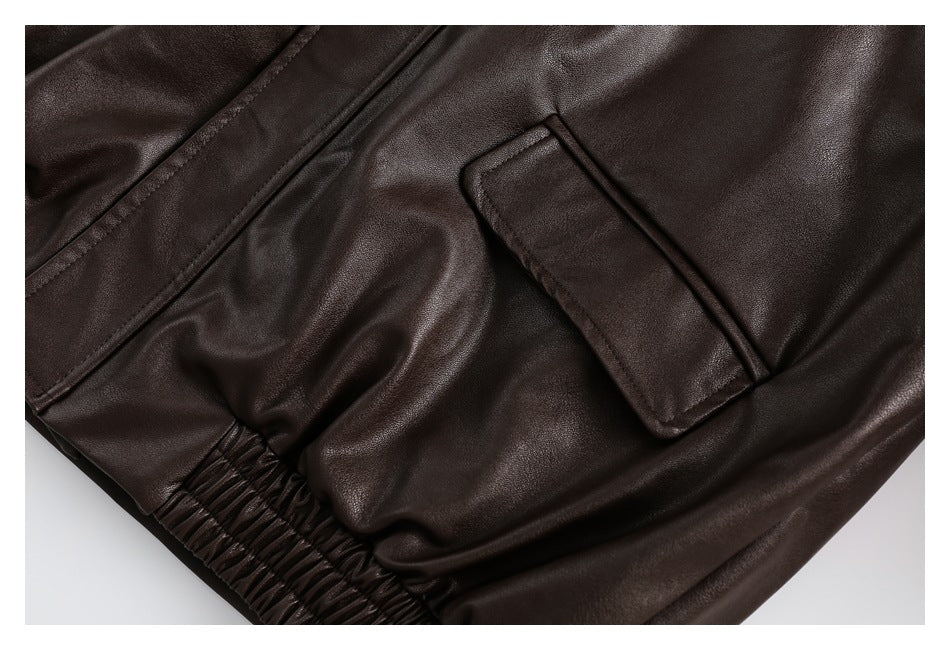Close-up of a flap pocket and gathered elastic waist on a dark brown garment.