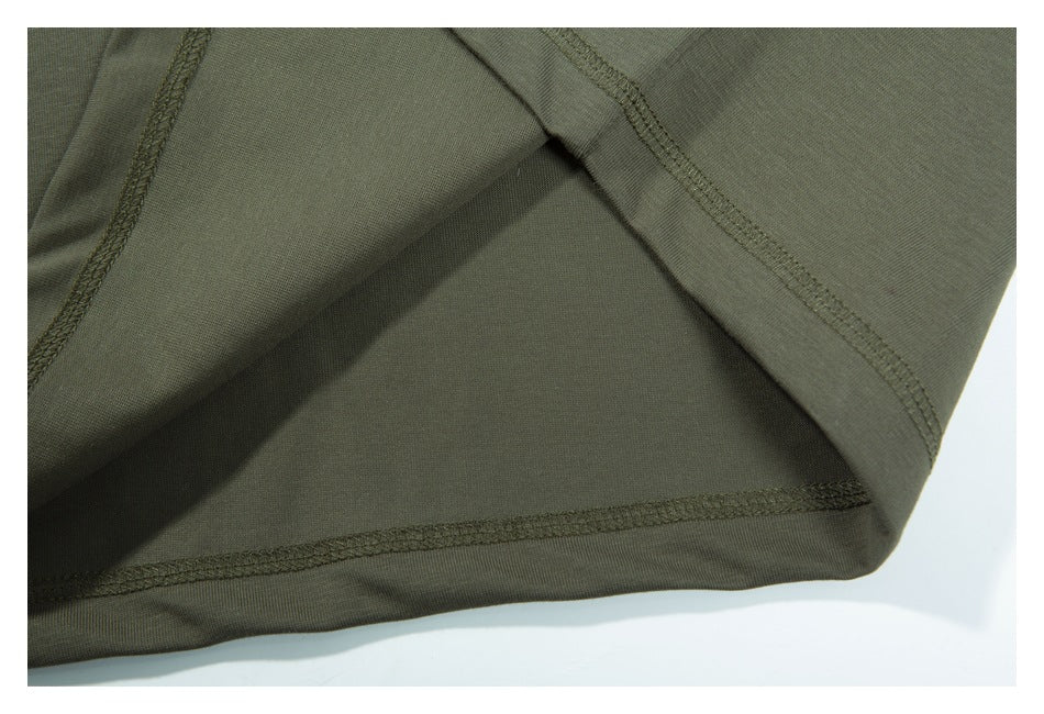Close-up of a dark olive-green garment hem and overlocked seams.