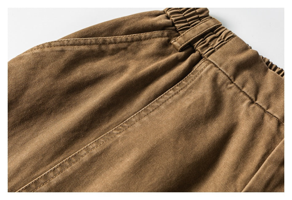 Close-up of the brown trousers' elasticated waistband, belt loop and stitched rear seam.