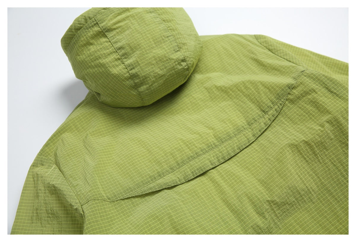 Close-up of the jacket's hood and back seam in olive green with a fine yellow grid pattern.