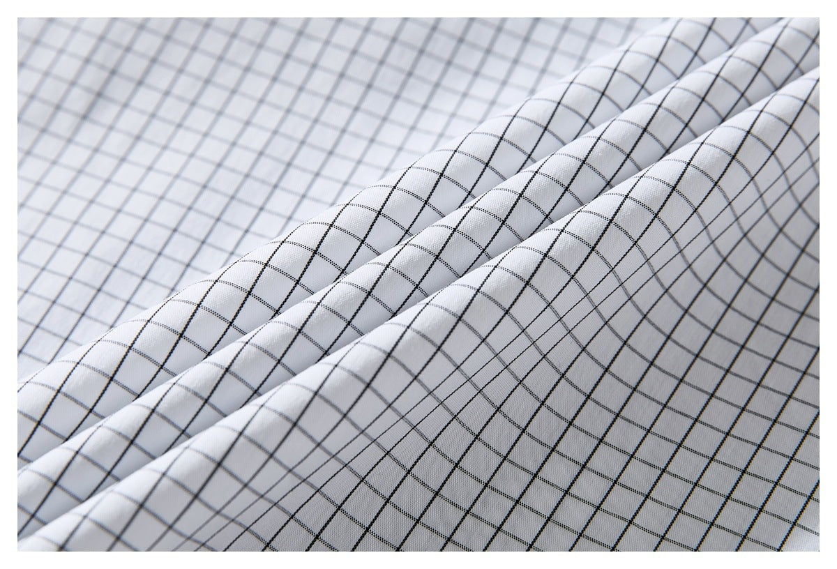 Close-up of the white shirt's black windowpane grid fabric gathered into diagonal folds.