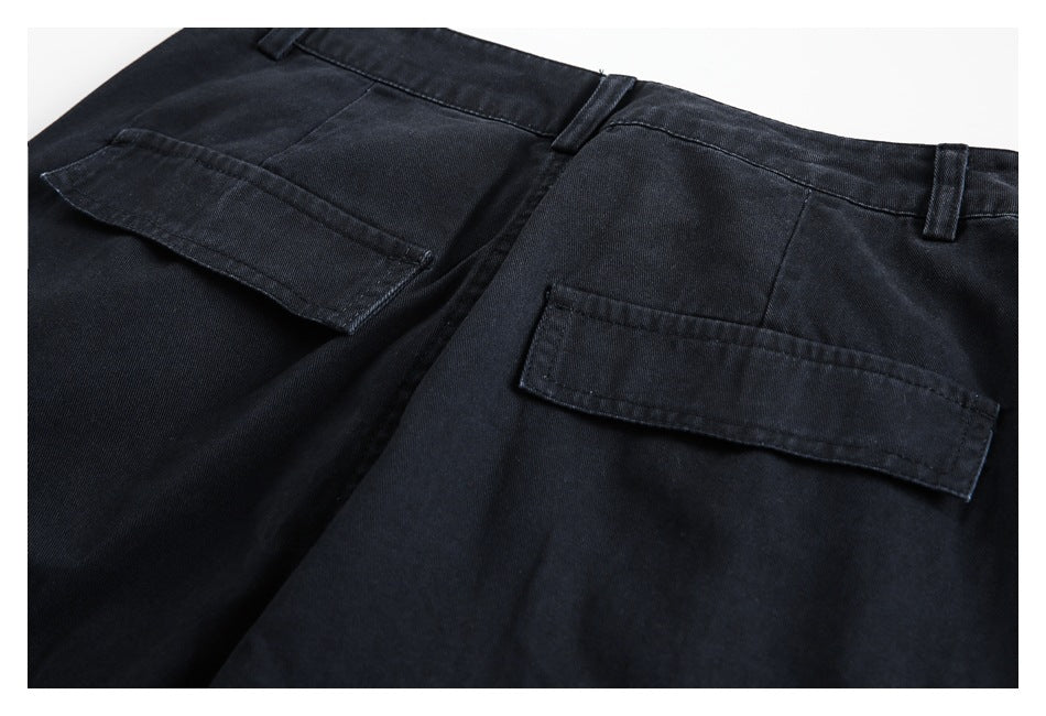 Flat-lay rear view of black trousers with two flap back pockets and belt loops.