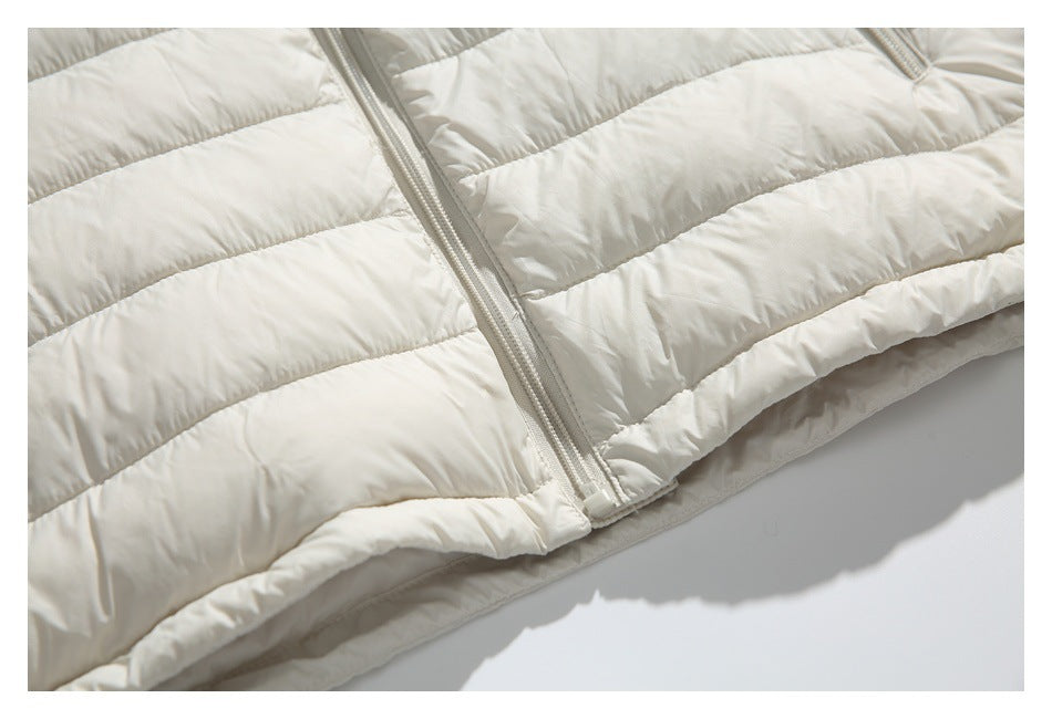 Close-up of the ivory quilted jacket's front zipper and finished lower hem.