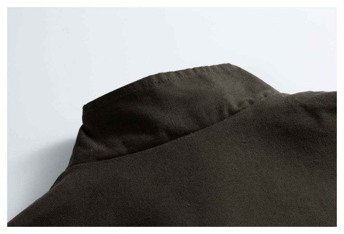 Close-up of dark charcoal textured garment fabric and a folded collar edge.