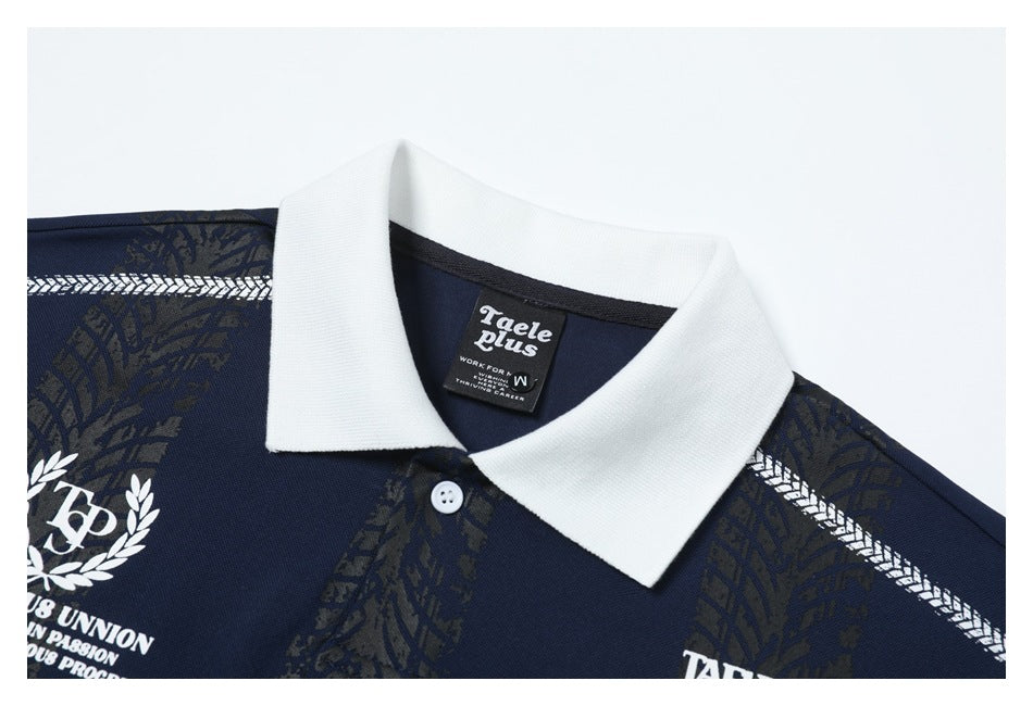 Close-up of a navy polo shirt with a white collar, button placket, patterned panels, and a sewn neck label.