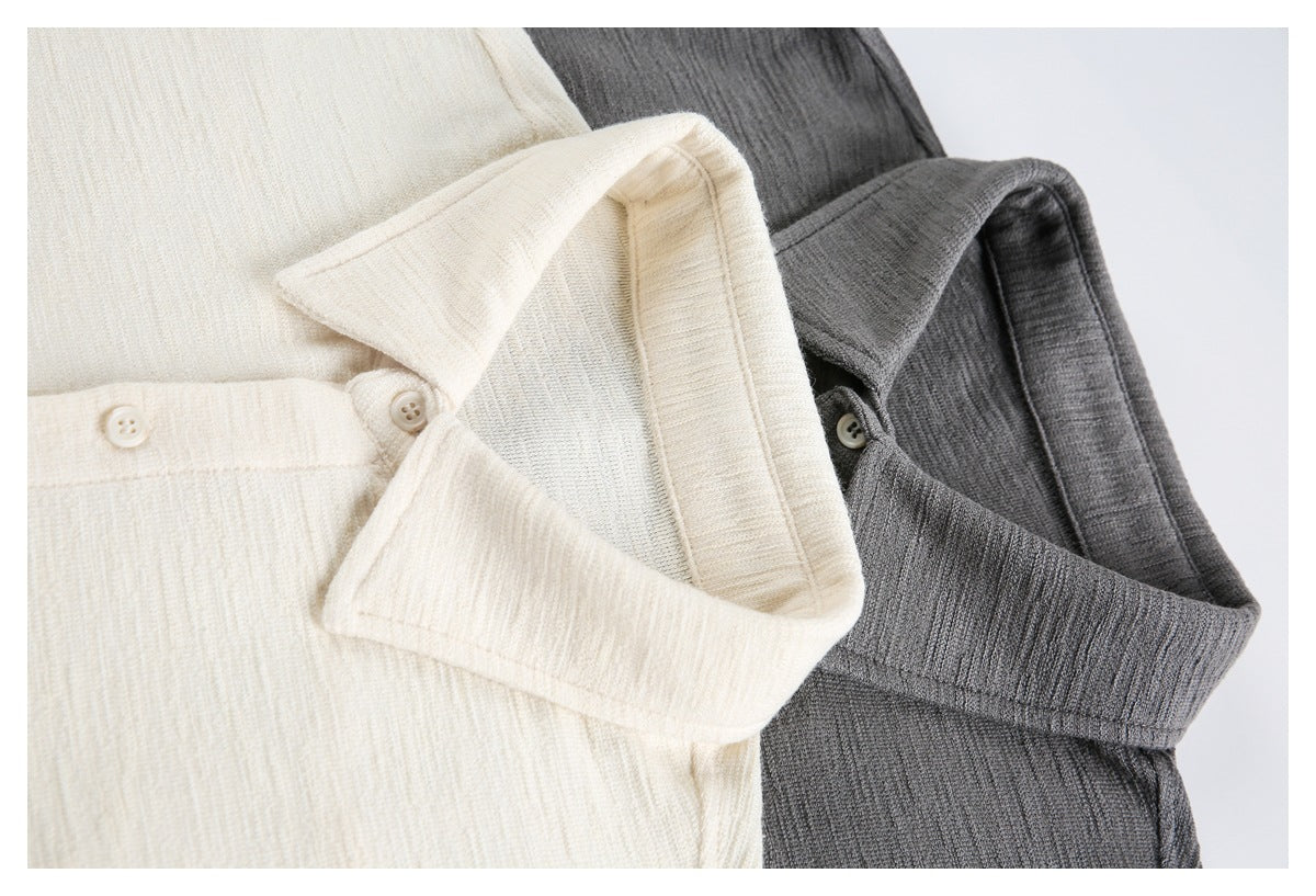 Cream and charcoal gray collared knit shirts shown together in a close-up front view.