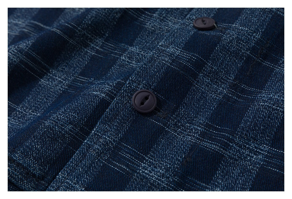Close-up of dark buttons and plaid fabric on a navy shirt.