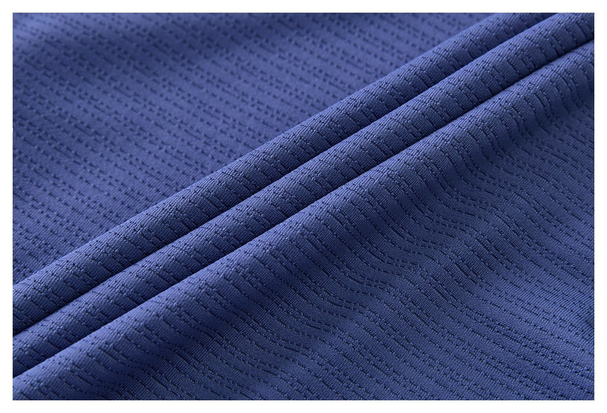 Close-up showing the blue shirt's textured fabric folded into ridges.