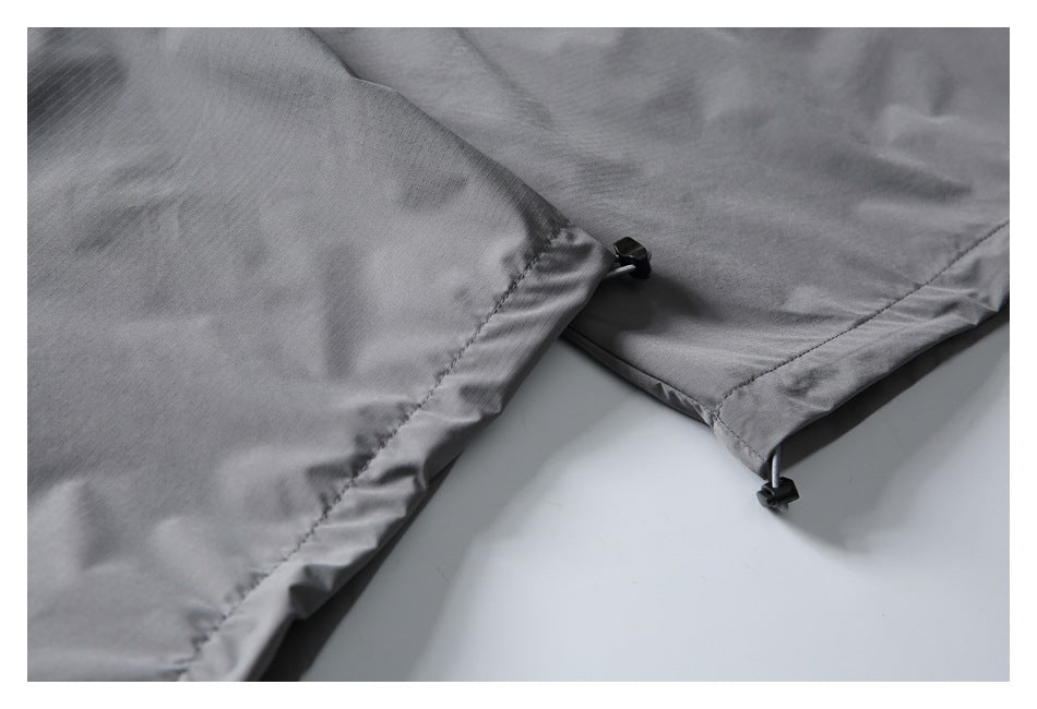 Close-up of gray pant hems with small black cord locks on the adjustable drawcords.