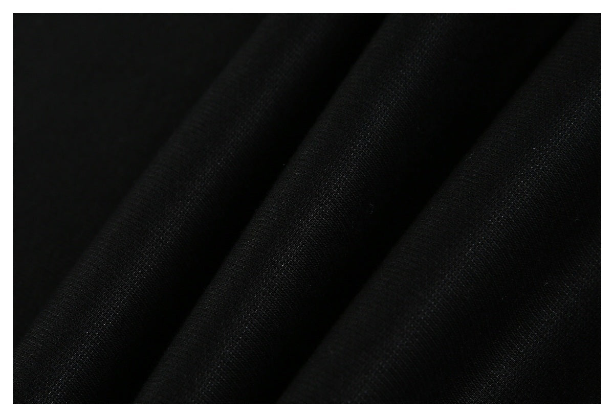 Macro view of black fabric draped in soft folds, showing its fine texture.