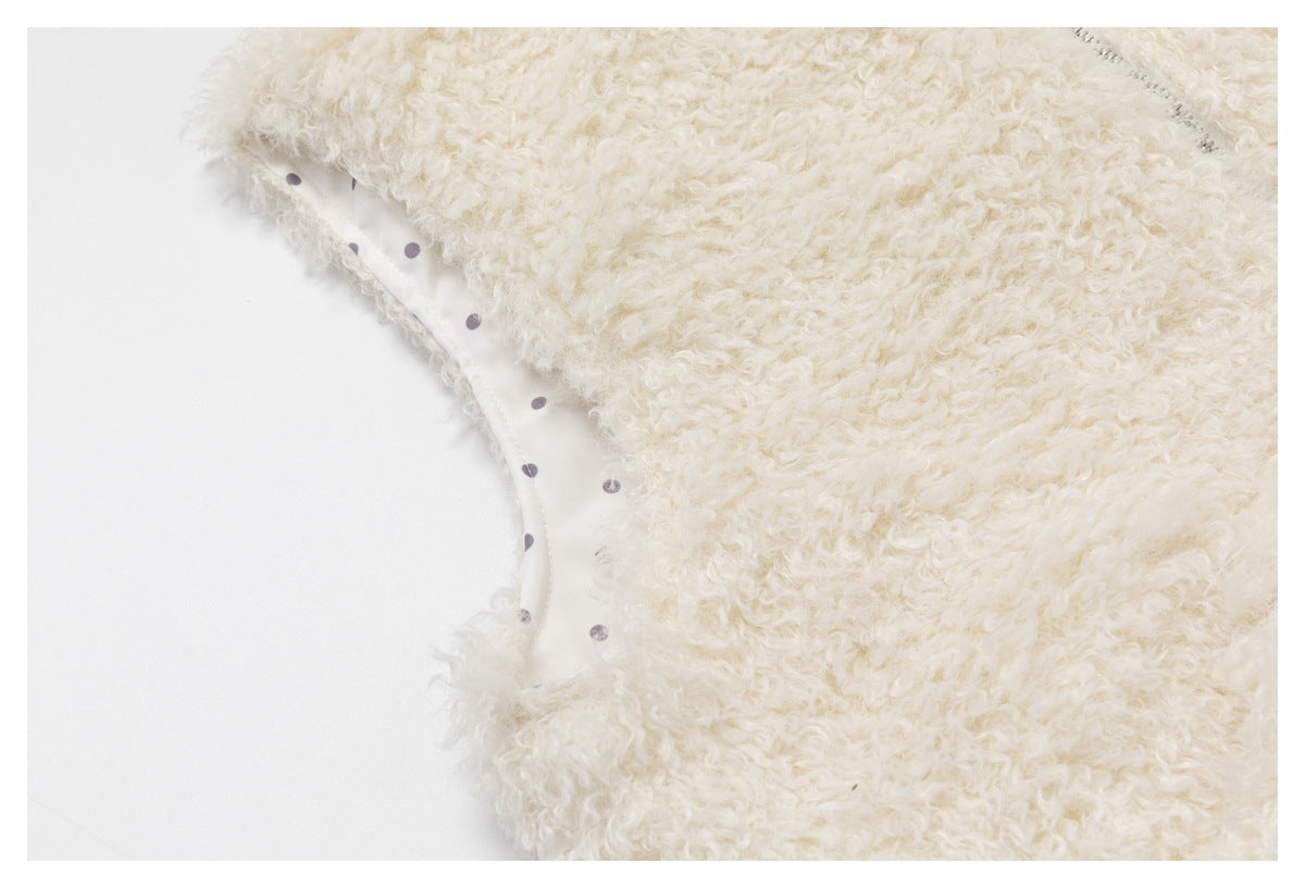 Cream curly-pile garment edge revealing white lining patterned with small dark dots.