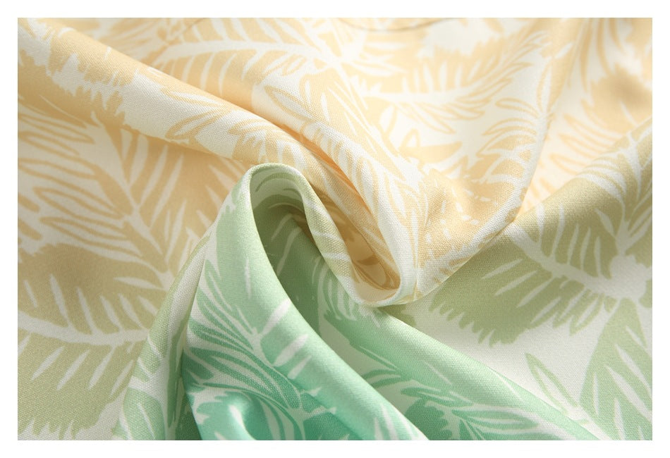 Close-up of draped cream and mint green fabric with a pale yellow leafy print.