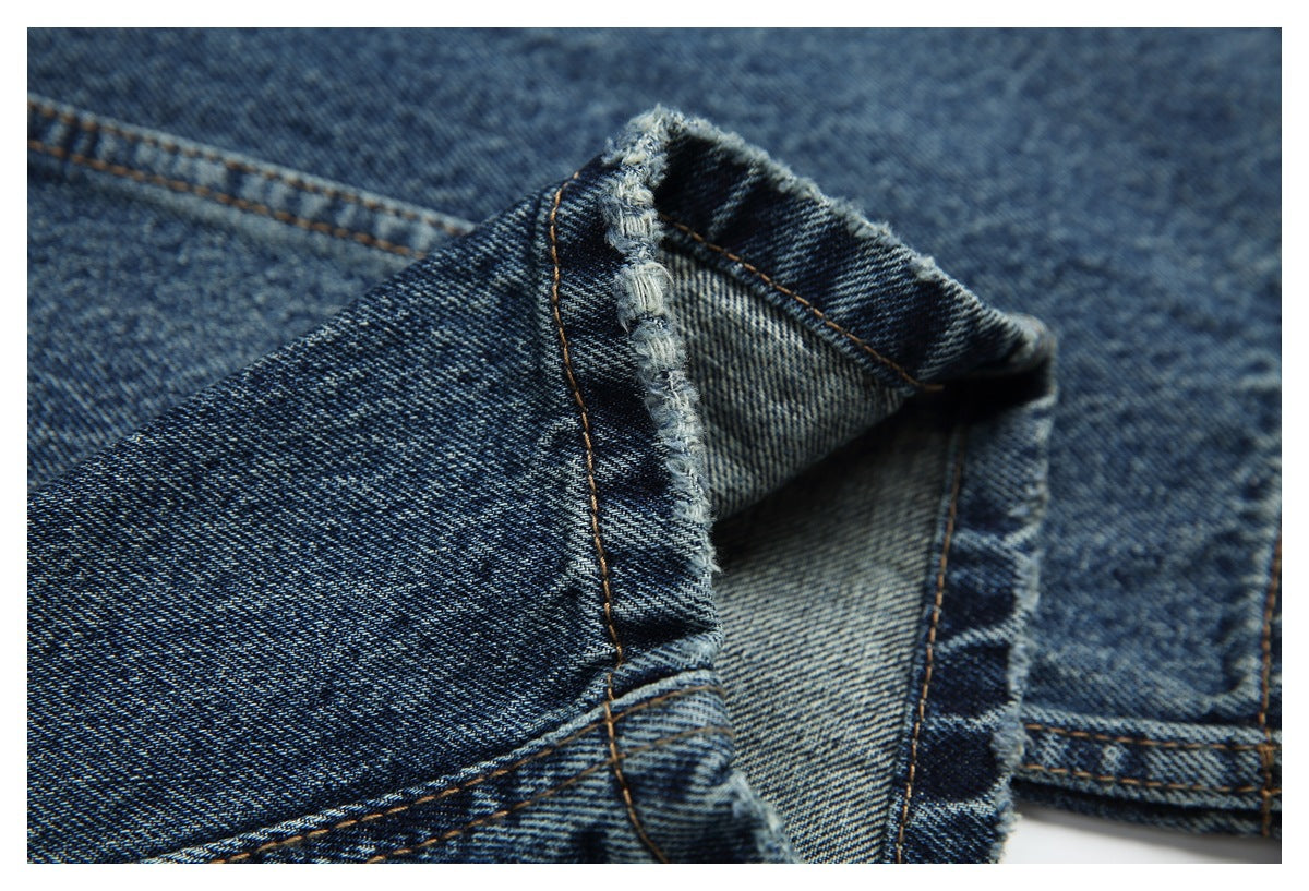 Close-up of a turned denim hem showing the inside fabric, folded edge, and stitching.