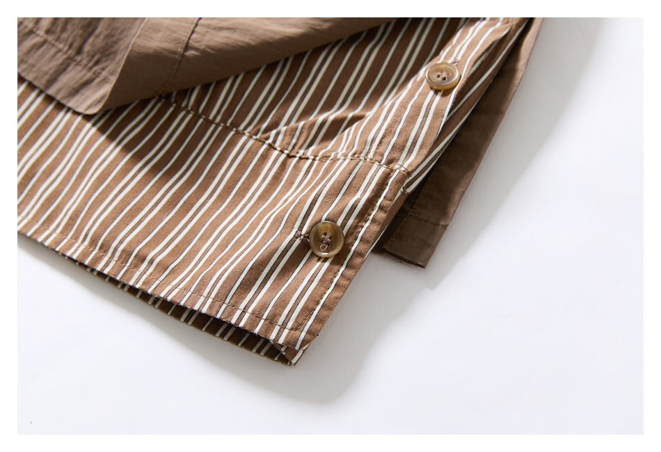 Close-up of brown-and-white striped lining and buttons inside the taupe trouser hem.