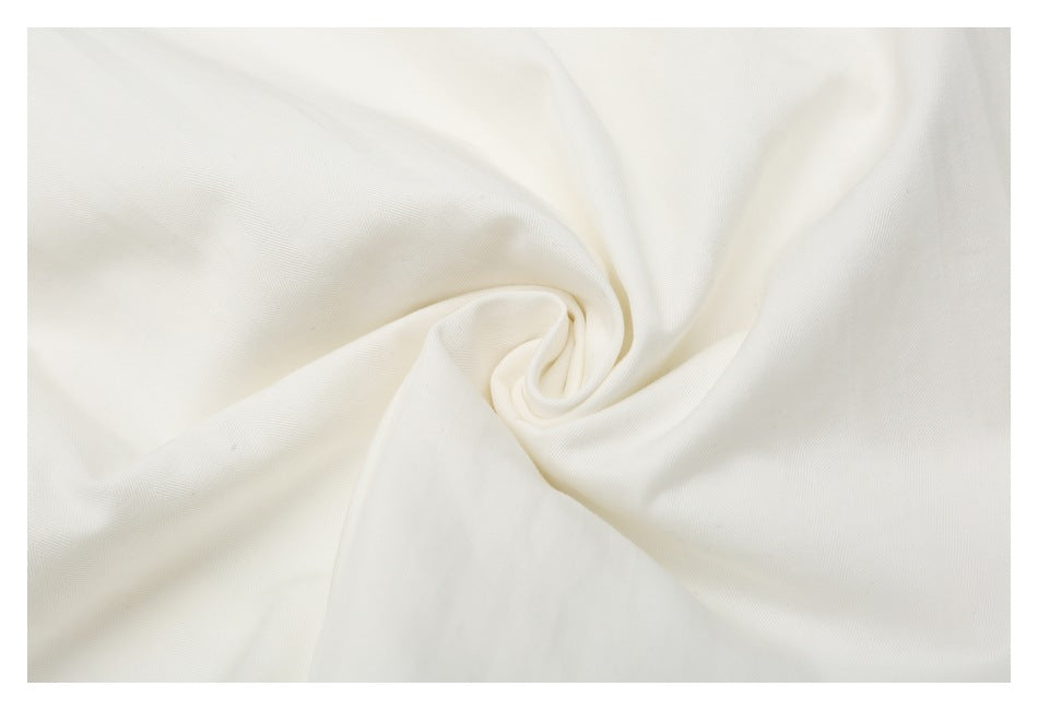Close-up of off-white fabric gathered into a soft spiral fold.
