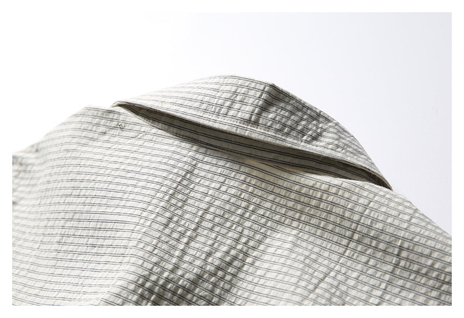 Close-up of a cream pinstriped shirt collar and neckline.