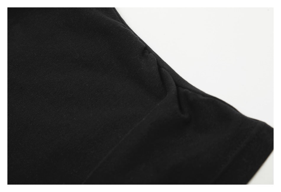 Close-up of black garment fabric and a stitched seam against a white background.