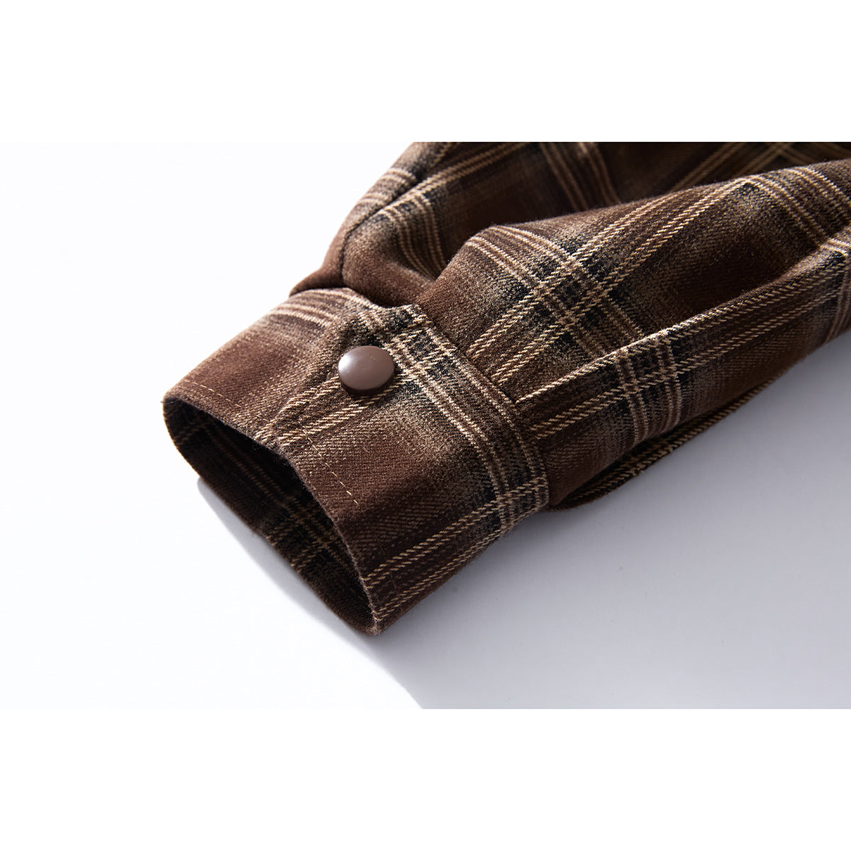 Close-up of a brown plaid jacket cuff with a single brown button.