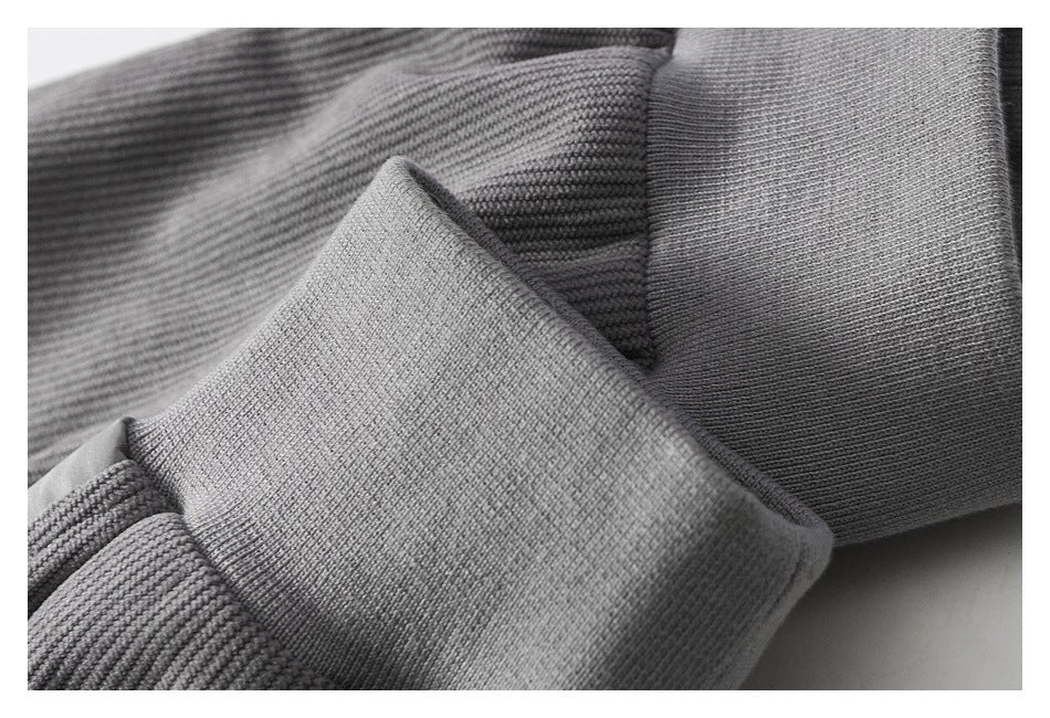Close-up of a gray rib-knit cuff and textured garment fabric.