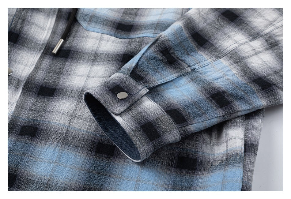 Close-up of the plaid shirt sleeve cuff with a metal snap fastener.