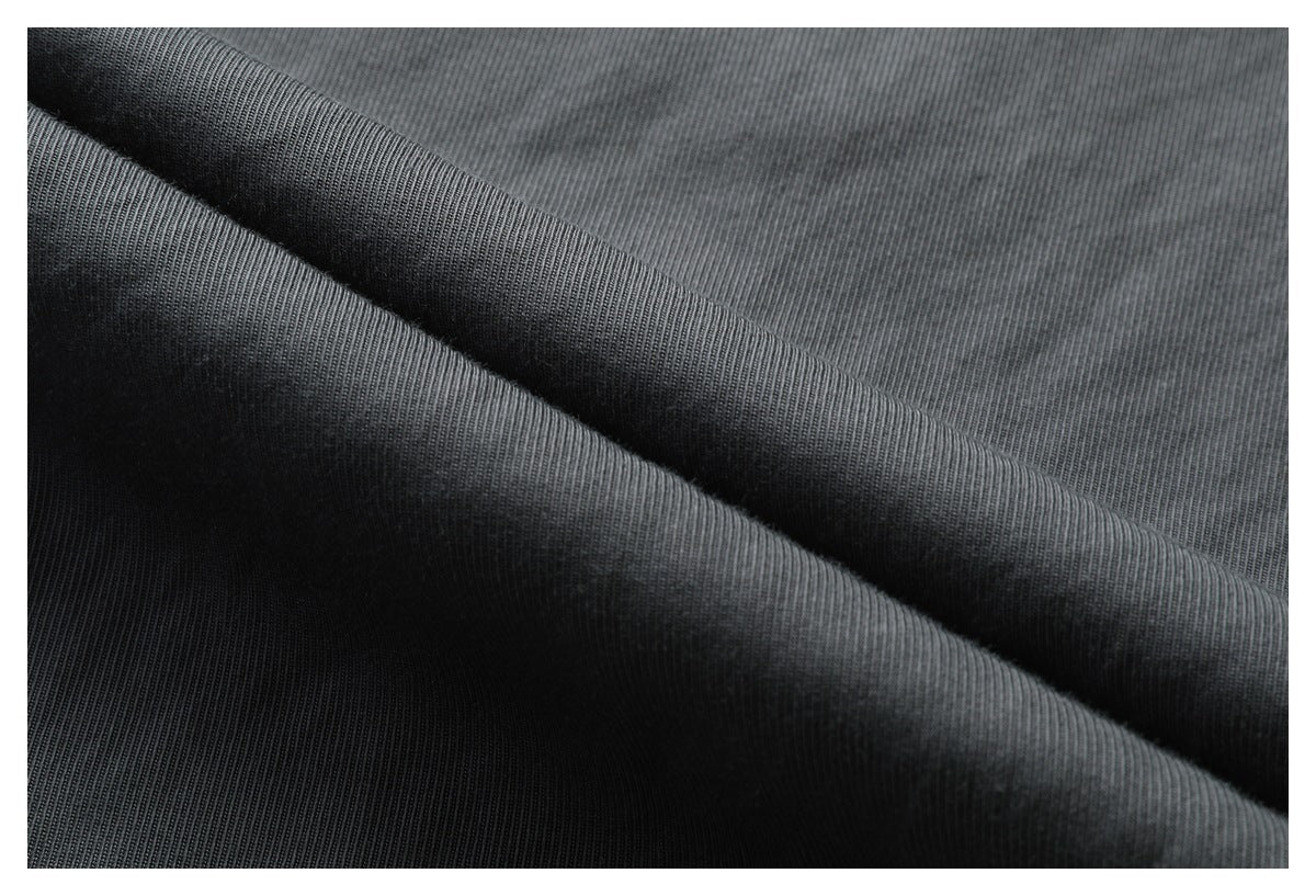 Close-up of charcoal fabric folded to show its fine, closely spaced vertical rib texture.
