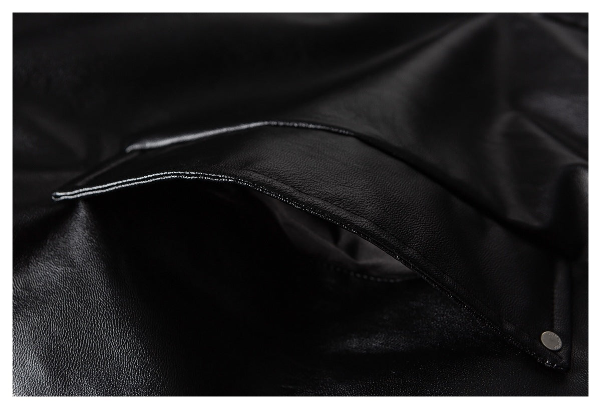Close-up of a black textured garment flap with a small metal snap.