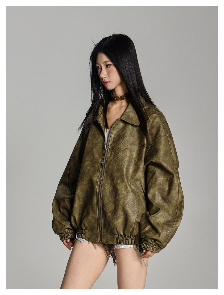 Model wearing an oversized olive-brown textured zip jacket with a wide collar and elastic cuffs and hem, front view.