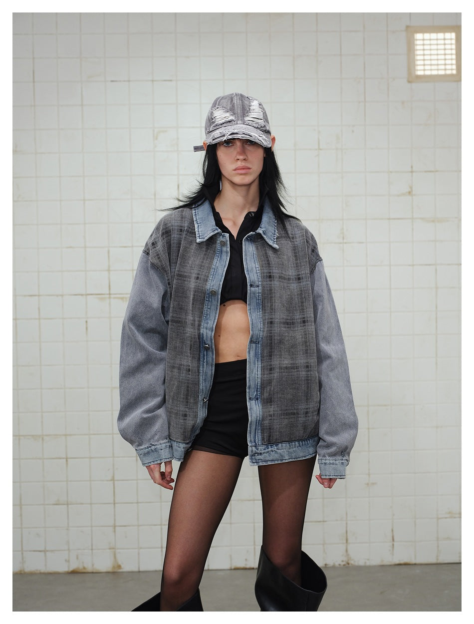 Model wearing a charcoal plaid jacket with light blue denim trim and oversized gray sleeves, styled with a distressed cap.