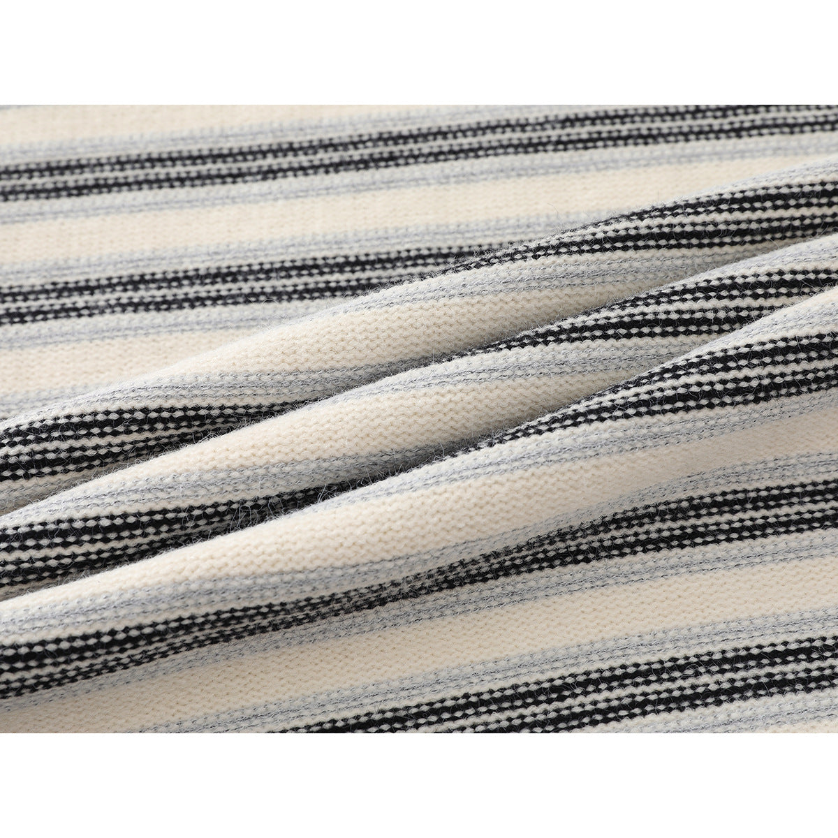 Close-up of the cream, gray, and black striped knit pattern, draped to show its texture.