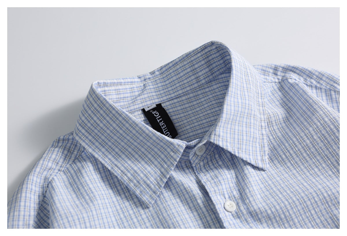 Close-up of the collar and front placket of a blue-and-white checked shirt, with a black neck label.