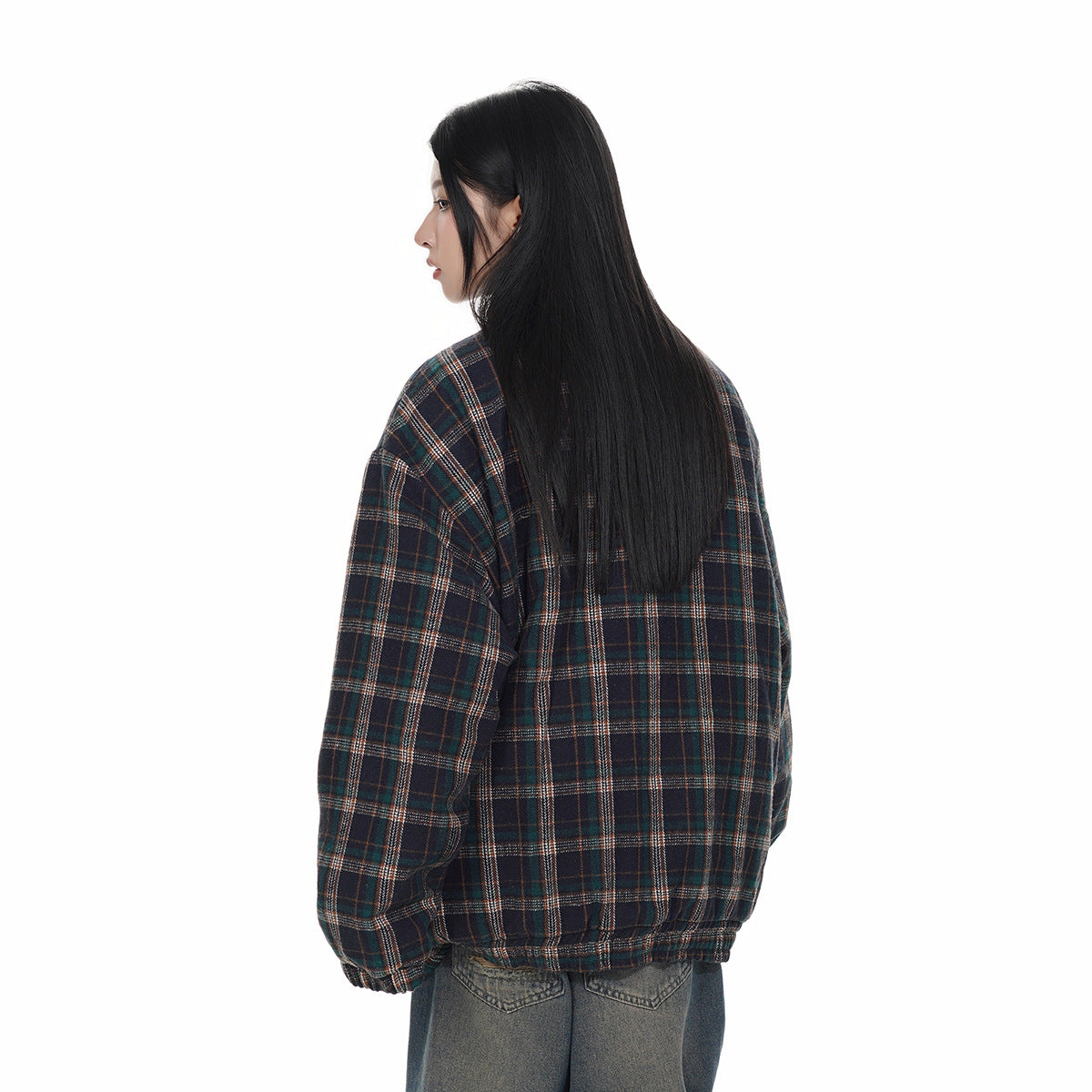 Rear view of a model wearing an oversized dark navy plaid jacket with gathered cuffs and hem, paired with gray jeans.