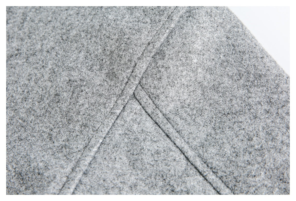 Close-up of the gray jacket’s intersecting seam lines and textured fabric.