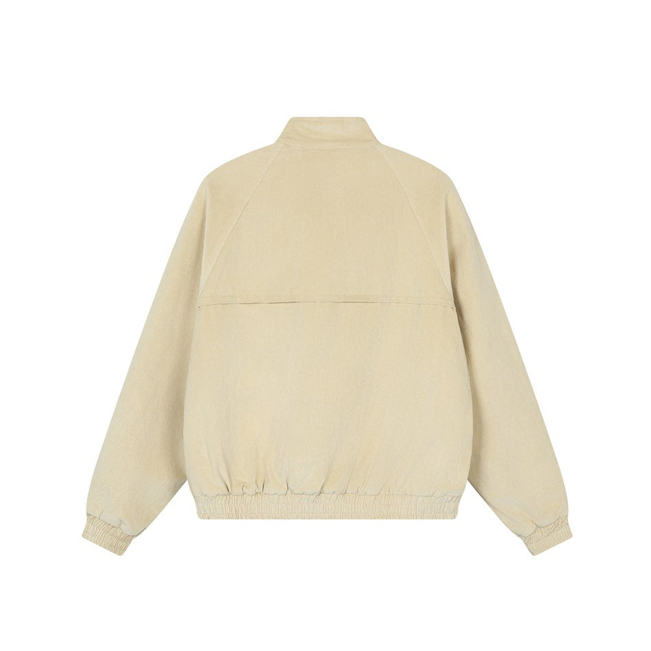 Back of a light beige jacket with a stand collar, raglan sleeves, horizontal yoke seam, and gathered cuffs and hem.