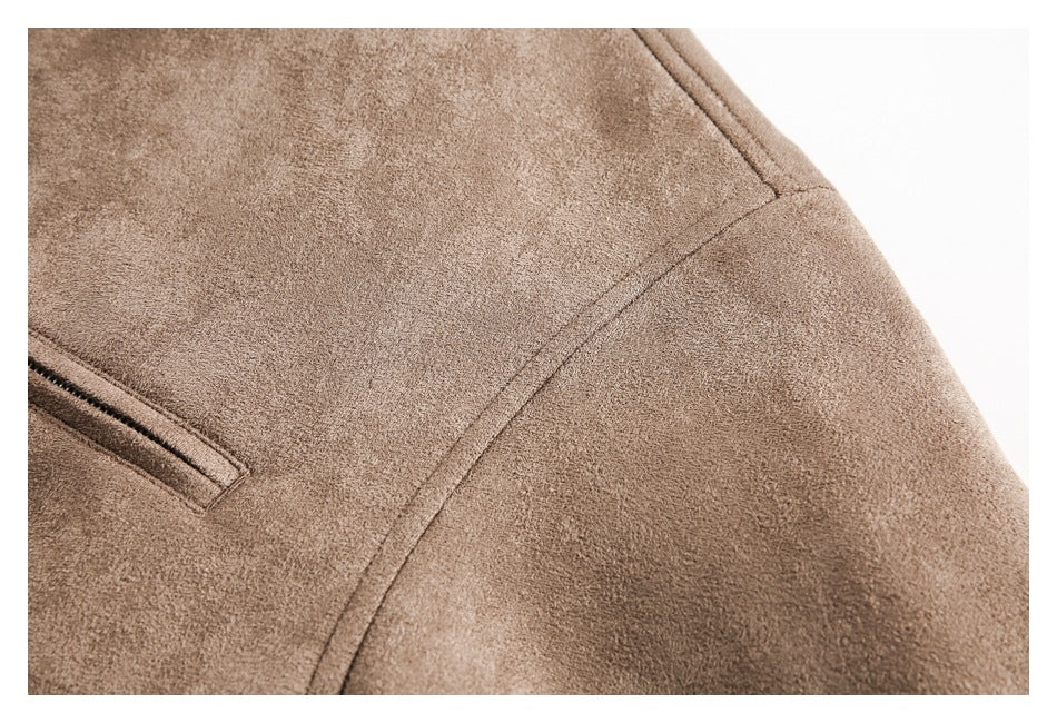 Close-up of brown jacket fabric, curved seam, and the edge of a pocket.