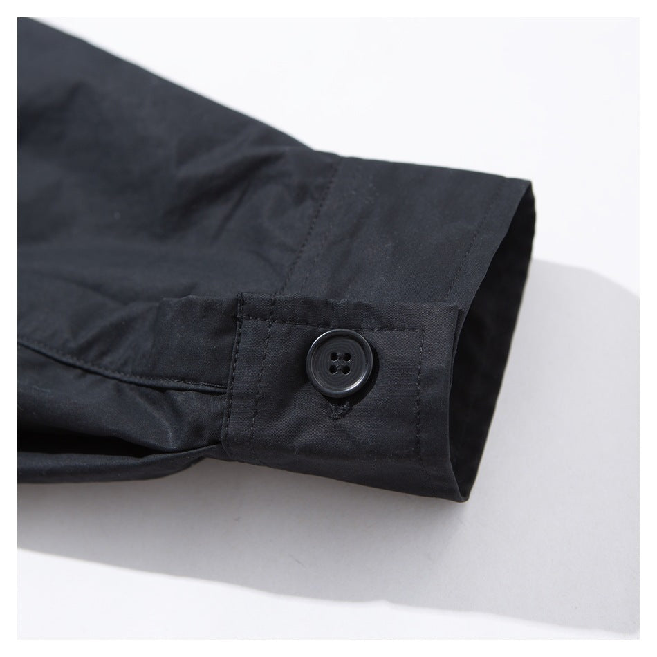 Close-up of a black sleeve cuff with a button closure and visible stitching.