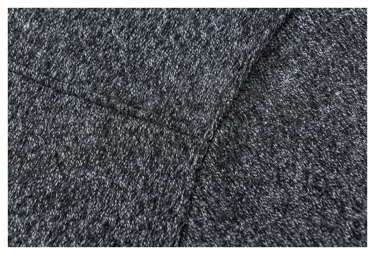 Close-up of stitching and seam lines in charcoal marled knit fabric.