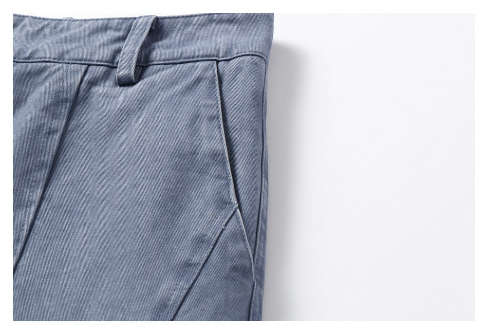 Close-up of the blue-gray trousers' waistband, belt loop, and angled side pocket opening.