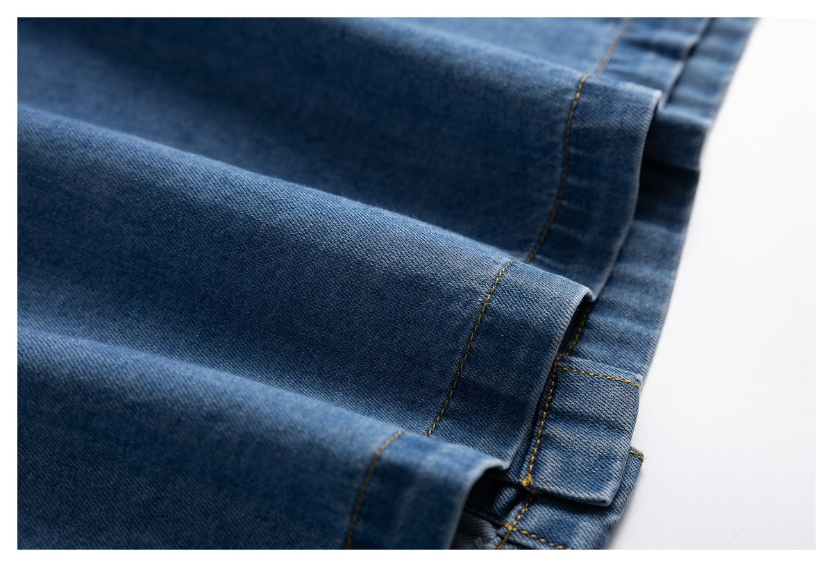 Close-up of blue denim garment hems with folded edges and contrast stitching.