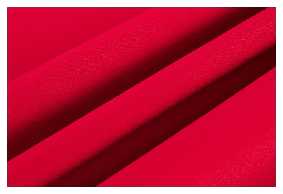 Close-up of smooth red garment fabric arranged in diagonal folds.