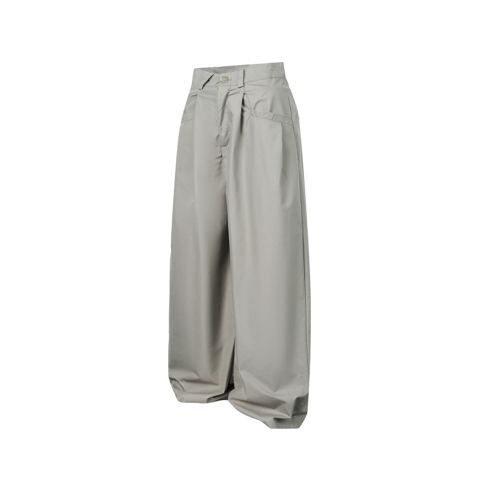 Front view of loose, wide-leg gray trousers with front pleats and slanted pockets.