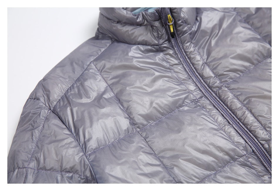 Close-up of a gray quilted jacket shoulder, raised collar, and front zipper.