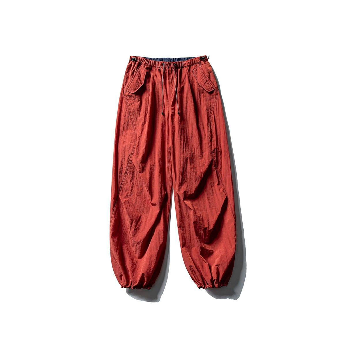 Red wide-leg pants with drawstring waist, flap pockets and gathered ankle cuffs, flat lay
