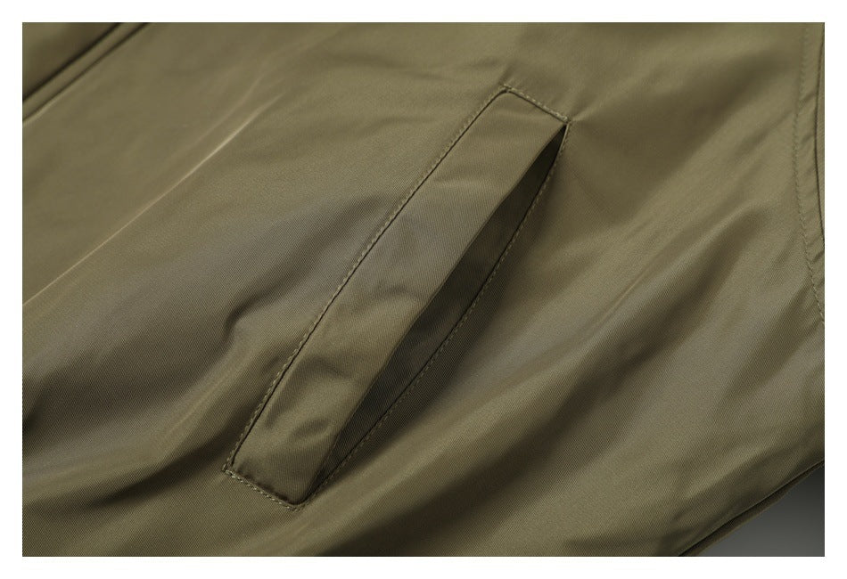 Close-up of the olive jacket’s slanted welt pocket.