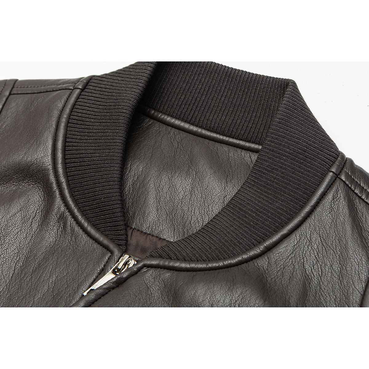 Close-up of a dark brown jacket's ribbed collar, piped neckline and silver front zipper.