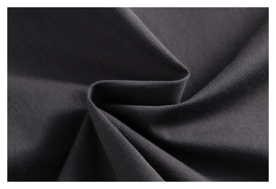 Close-up of dark charcoal ribbed knit fabric folded into soft ridges.