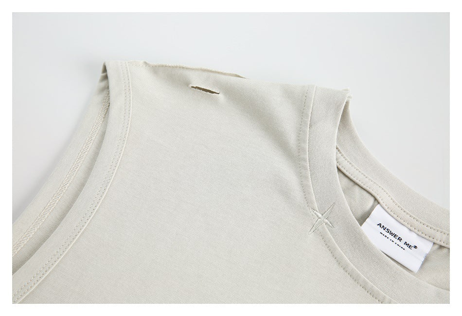 Close-up of the ivory shirt's shoulder seam, neckline, stitched accent, and a small slit.