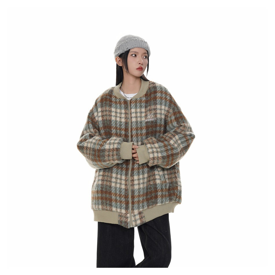 Model wearing a cream-trimmed plaid zip jacket in beige, gray, and rust, with black pants.