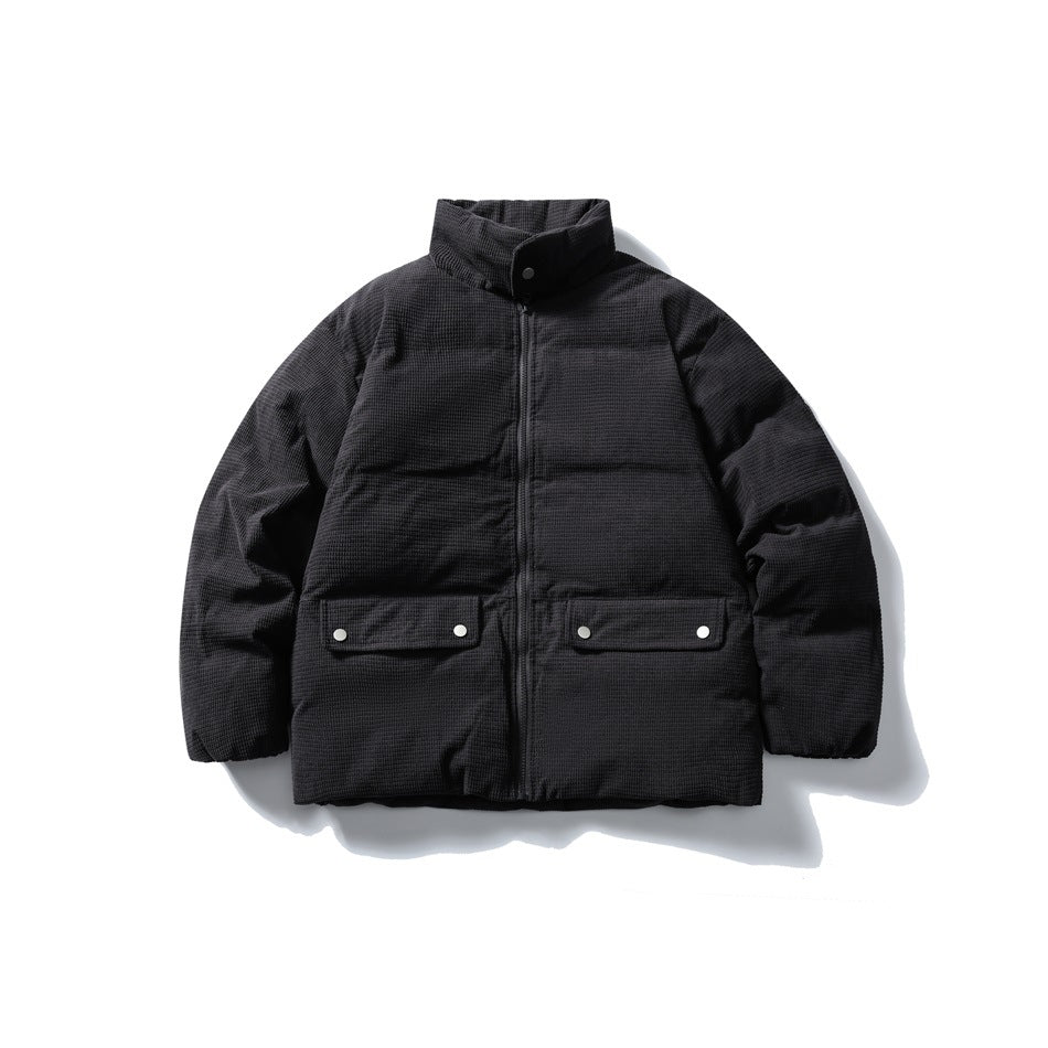 Dark gray quilted stand-collar jacket with front zip and two snap flap pockets, flat lay